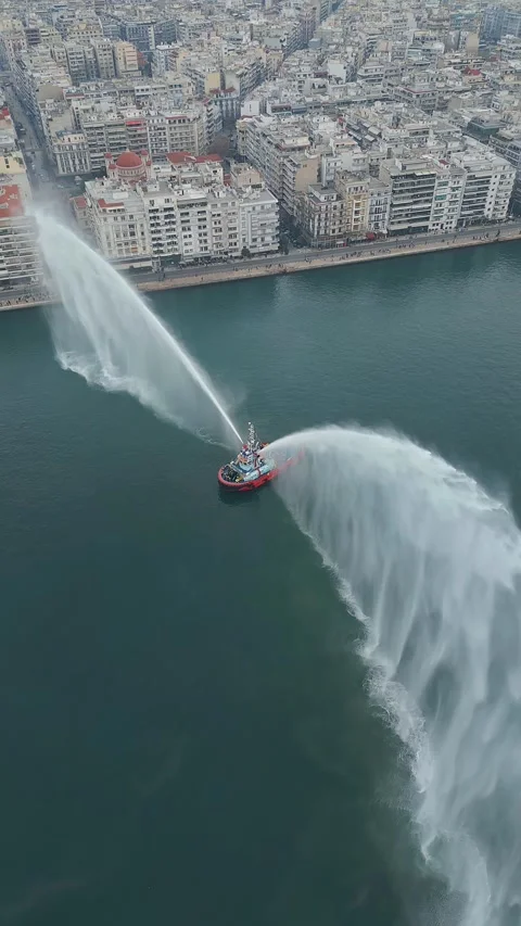 Vertical orbit fireboat water salute port thessaloniki 4k Stock Footage 333458116