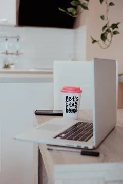 Vertical orientation work from home. view to kitchen table laptop and coffee mug Stock Photos
