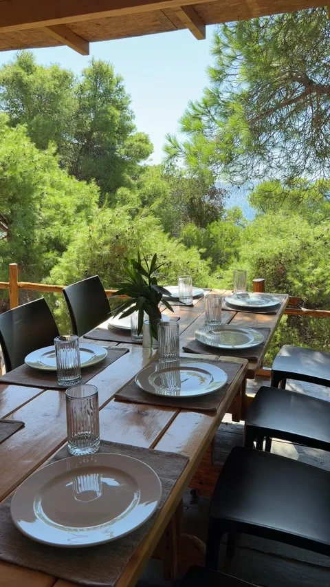 Vertical outdoor dining setting surrounded by lush Mediterranean trees Stock Footage 319407305