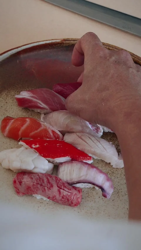 Vertical over shoulder chef plating nigiri assortment 4K Stock Footage 317504691