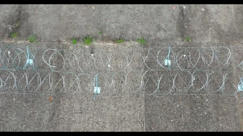 Vertical Overhead Track Along Razor Wire Rows on Concrete Stock-Footage 344129623