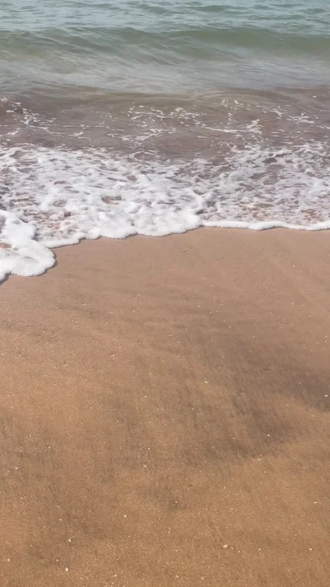 Vertical Overhead View of Small Ocean Wave Breaking on Sandy Beach Stock Footage 340774820