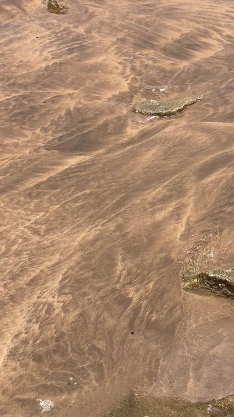 Vertical Overhead View of Water Flowing Over Wet Sand Stock Footage 340775123