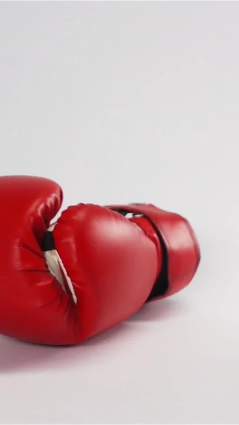 Vertical of Pair of red leather boxing gloves falling and bouncing isolated on Stock Footage 305499559