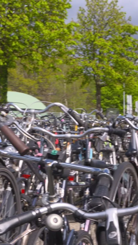 Vertical - pan across bicycle parking facility at railway station Stock Footage 312456984