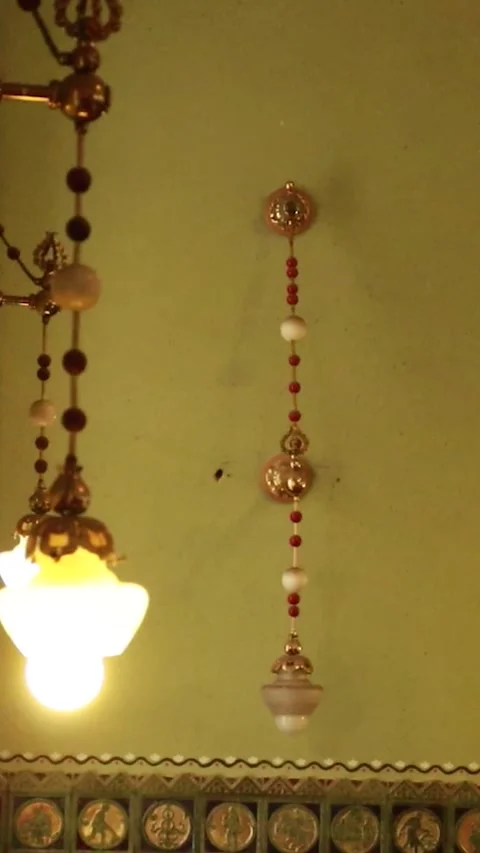 Vertical Pan Left Across Glowing Vintage Chandelier in Synagogue 库存影片 330368562