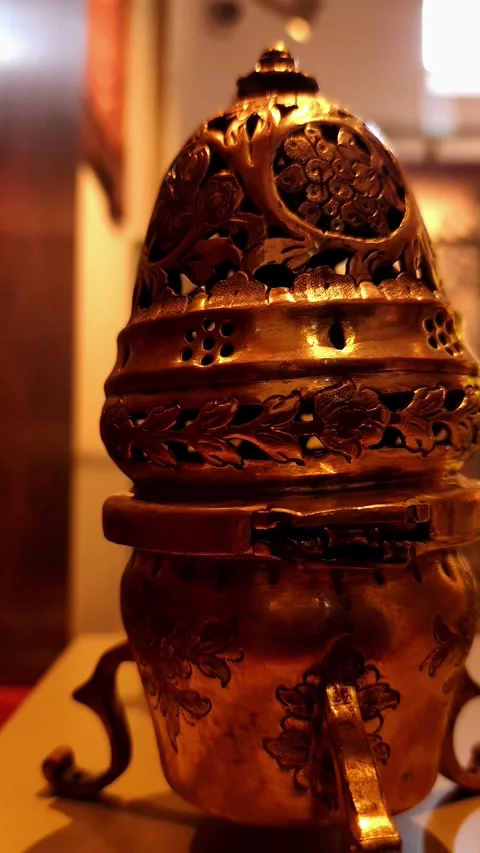 Vertical pan from left to right revealing an ornate antique brass incense burner Video stock 334108730