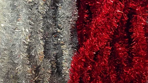 Vertical pan over a row of assorted colorful Christmas tinsel Stock Footage 344674803