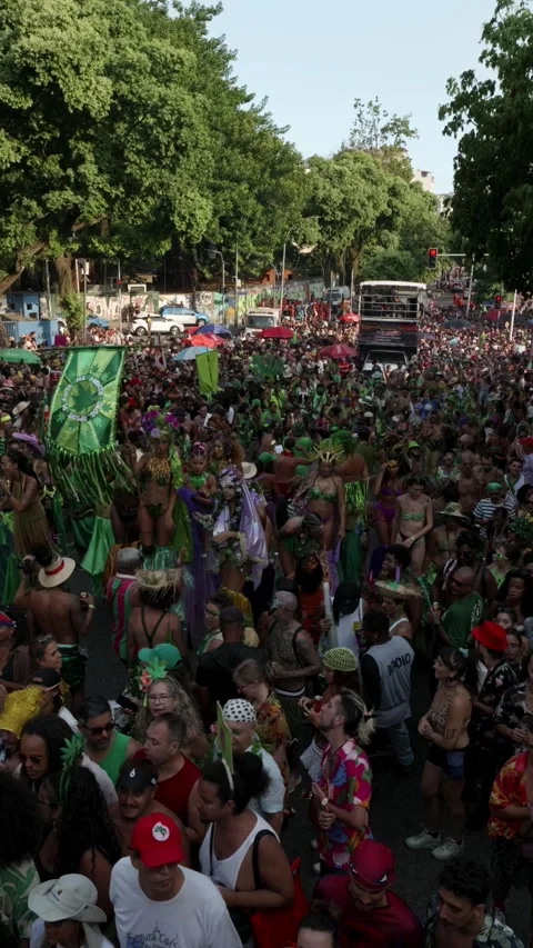 Vertical pan right across a crowded Rio Carnaval bloco with people dancing near Stock Footage 336296049