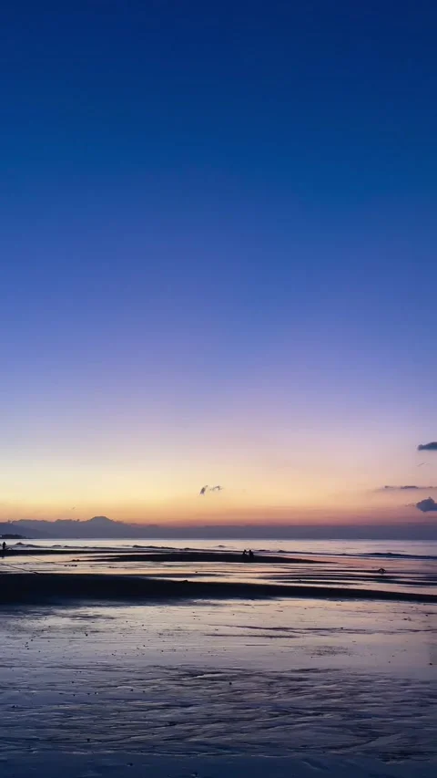 Vertical pan shot of peaceful beach dawn with blue sky in Bali Vidéo 343796774