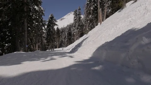 Vertical pan up on a ski slope in the mountains overlooking a winter landscape  Stock Footage 127589461