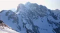 Vertical pan of snowy mountains and bright sun in blue sky. Winter landscape 4k or 4k+ Resolution