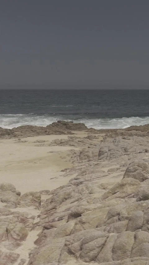 Vertical Pan of Waves &amp; Rocks Stock Footage 285565449