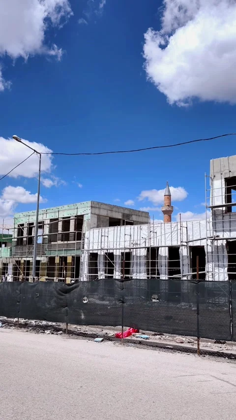 Vertical panning shot of a construction site along a road. Features a wide Video stock 333908471