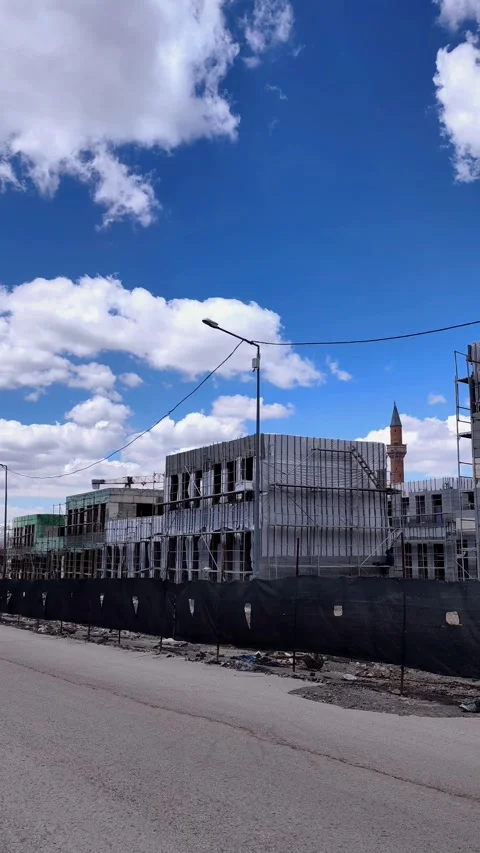 Vertical panning shot of a construction site along a road. Features a wide Vídeos de archivo 333908572