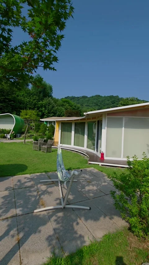 Vertical panning shot of Glam Tree glamping resort with modern outdoor setting Stock Footage 313324253
