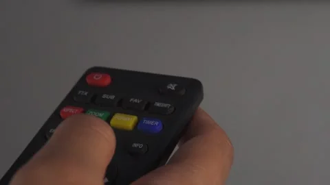 Vertical panning shot of hands using remote on tv Stock Footage 276716830