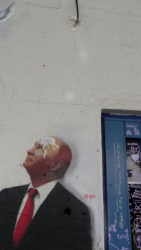 Vertical. Panning shot of mural or graffiti showing Putin soiled. Видео 300117261