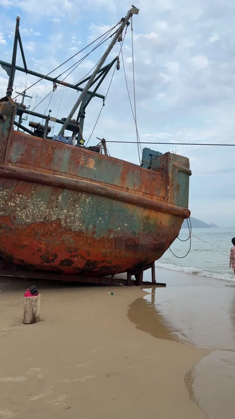 Vertical - Panning View of a Massive Rusted Ship Stranded on Beach Stock Footage 330945747