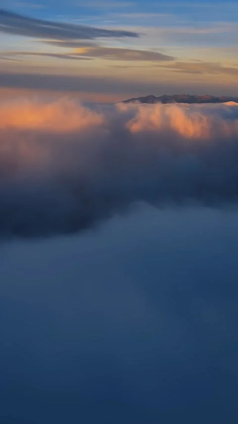 Vertical panoramic view of fluffy clouds at sunrise in misty mountains nature Stock Footage 307709992