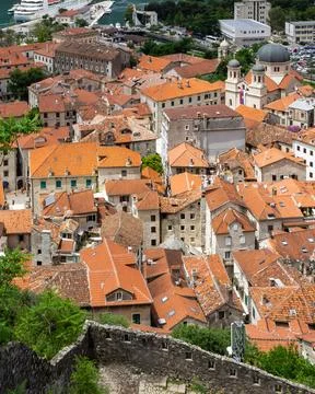Vertical panoramic view of Old Town Kotor with red tiled rooftops and Bay of Stock Photos
