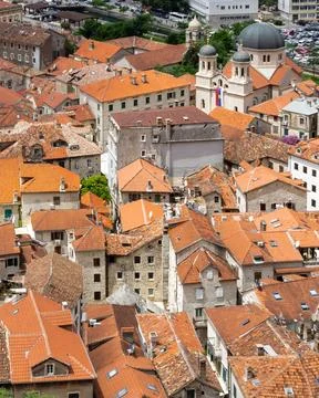 Vertical panoramic view of Old Town Kotor with red tiled rooftops and Bay of Stock Photos