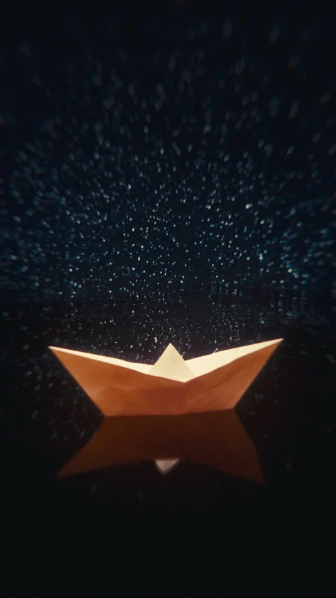 Vertical paper boat floating in starry ocean at night — 4K dreamy loop Stock Footage 320413772