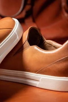 Vertical partial view of a pair of brown solid slip shoes over the wooden table Fotos Stock