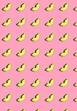 Vertical pattern with avocado slices on a pink background. Stock Photos