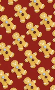 Vertical pattern of gingerbread Christmas cookies on red background Stock Photos
