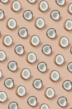 Vertical pattern from ripe tropical coconut's halves on a beige background. Stock Photos