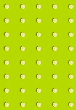 Vertical pattern with a round slice of juicy lime on a green background. Citrus Stock Photos