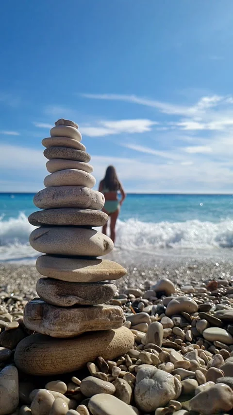 Vertical Pebble tower against blue sea Slow Stock Footage 305844187