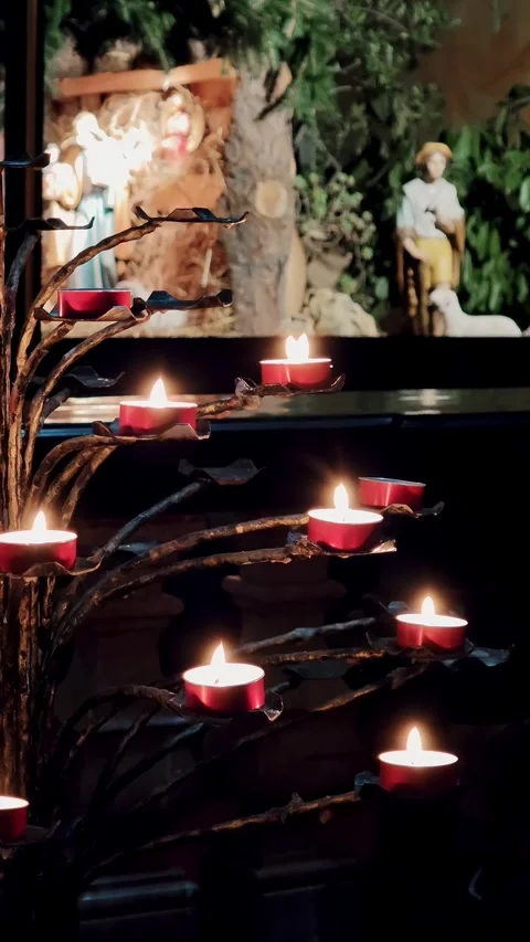 Vertical perspective of a candle stand with religious statues visible in the Stock Footage 329256851