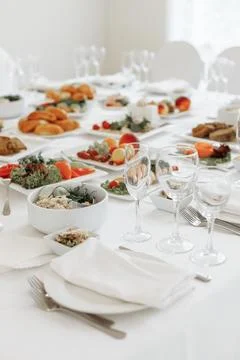 Vertical perspective looking down a long, elegantly served banquet table filled Stock Photos