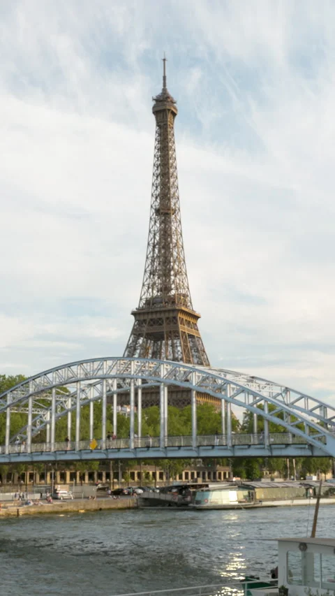 A vertical perspective of the majestic Eiffel Tower rising high behind the steel Stock Footage 336363098