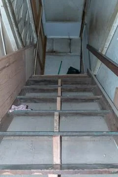 Vertical perspective showing a narrow set of wooden stairs leading upward b.. Stock Photos