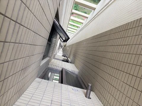 Vertical Perspective of Tall Building Interior Shaft with Windows and Tiles Foto stock