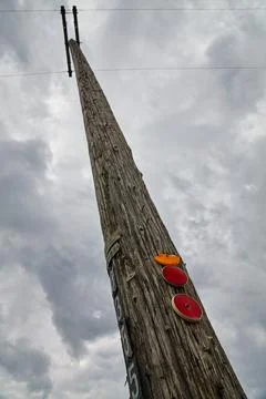 Vertical Perspective Weathered Utility Pole Reflective Markers and Cloudy Sky 스톡 사진