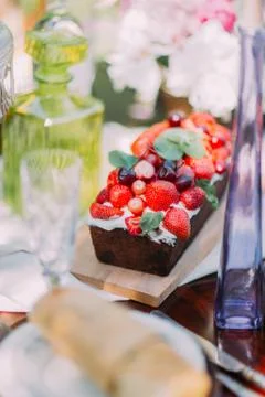 The vertical photo of the chocolade sponge fruit cake decorated with red berries Stock Photos