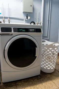 Vertical photo of a large front-loading washing machine with a laundry basket Foto stock
