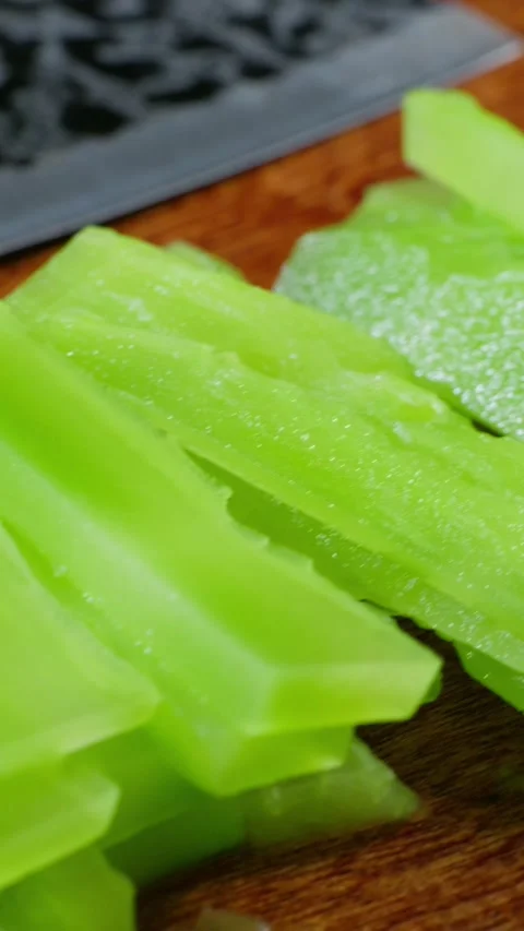 Vertical: Piled thin slices of lettuce stem stacked together Stock Footage 341837436