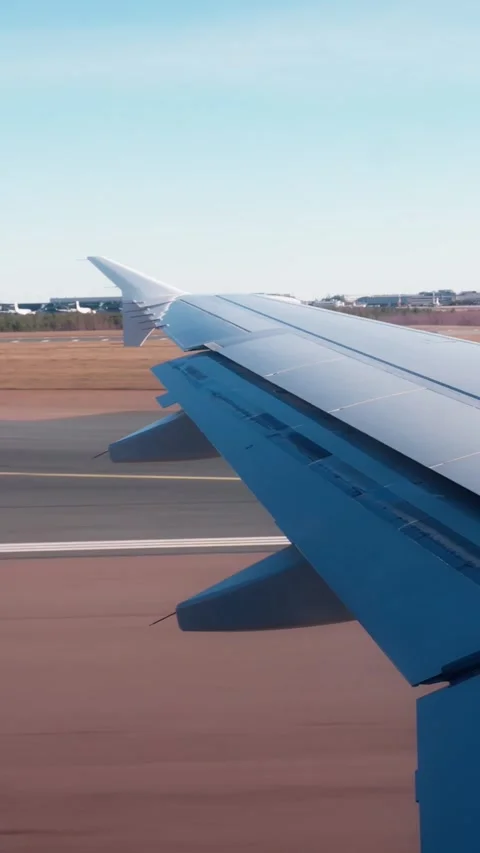 Vertical plane wing shot during takeoff roll, showing extended flaps, runway Stock Footage 333655849