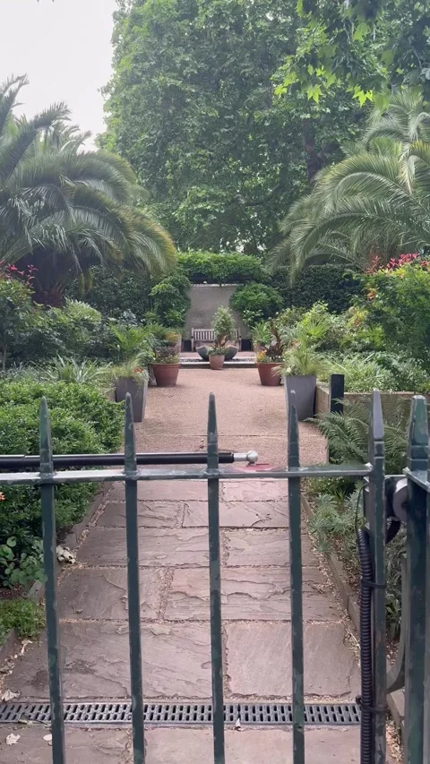 Vertical point of view walking movement through gate into secret garden in Londo Video stock 336927692
