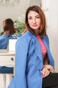 Vertical portrait of attractive red-haired woman in a jacket draped over her  Stock Photos