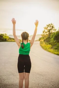Vertical portrait back view cute girl in tracksuit is engaged in sports act.. Stock Photos