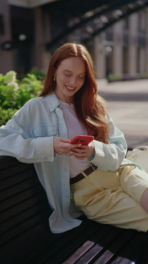 Vertical portrait of beautiful cheerful young woman with red hair sitting on Stock Footage 342808531