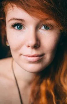 Vertical portrait of a beautiful red-haired curly girl with make-up and jewel 库存照片
