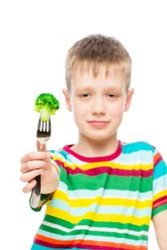Vertical portrait of a boy with broccoli on a fork, vegetable in focus Stock Photos