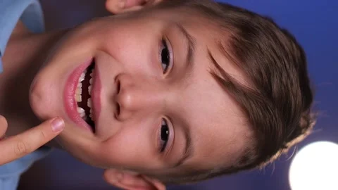 Vertical portrait of a boy with a missing tooth boy shows that he has no teeth Stock Footage 241836577